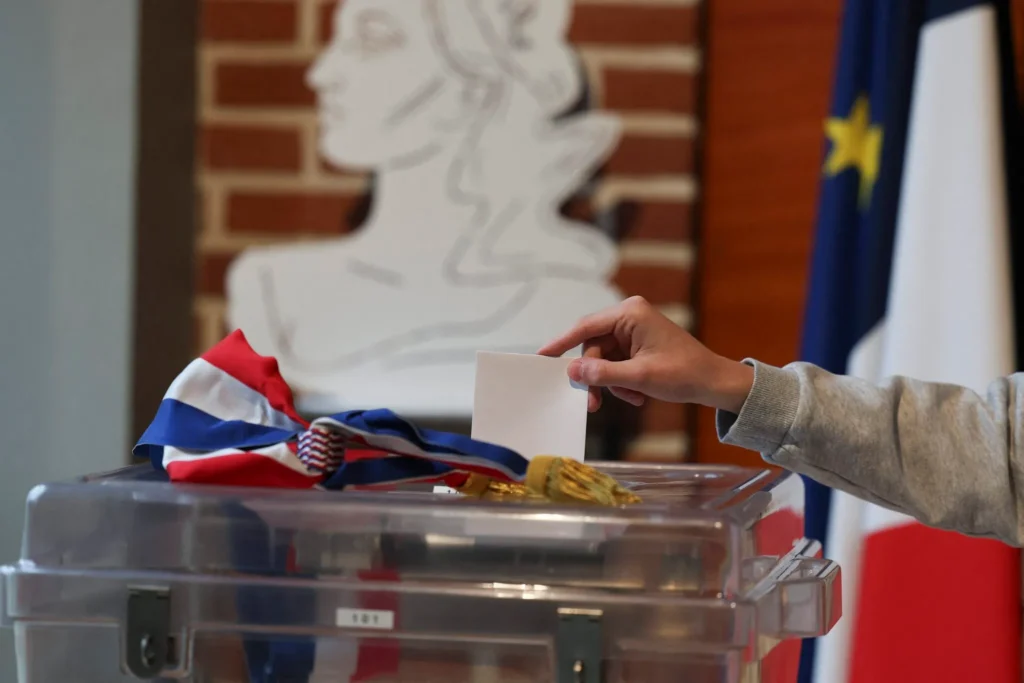 Un citoyen entrain de mettre son bulletin dans l'urne pour les élections