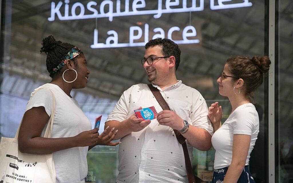 Des jeune devant le kiosque La place à Paris