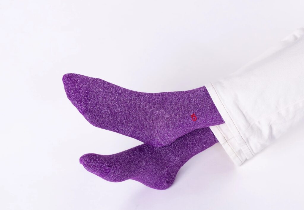 Une femme avec au pied des chaussettes à paillettes